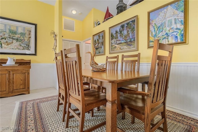 tiled dining space featuring lofted ceiling