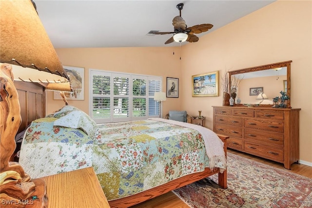 bedroom with ceiling fan, wood-type flooring, and lofted ceiling