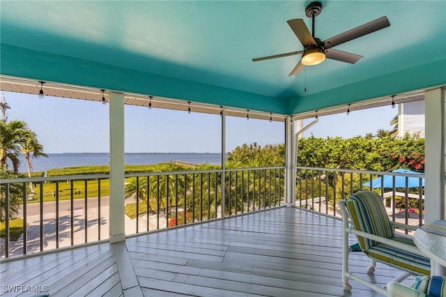 unfurnished sunroom with a water view and ceiling fan