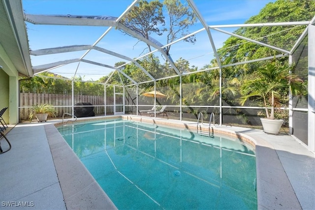 view of swimming pool featuring glass enclosure and a patio area