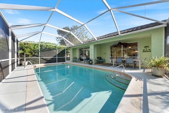 view of pool with ceiling fan, a patio area, and glass enclosure