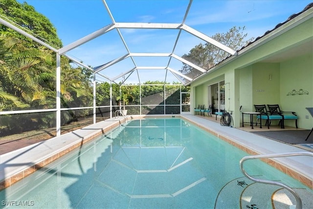 view of swimming pool featuring a patio area and a lanai