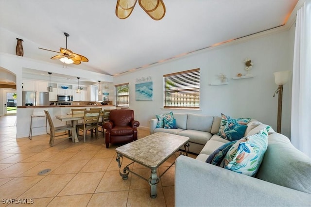 living room featuring light tile patterned floors, ceiling fan, and crown molding