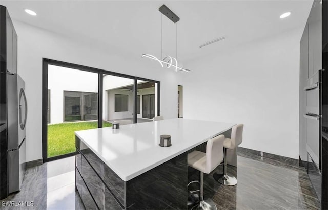 kitchen featuring pendant lighting, a large island, and a kitchen bar