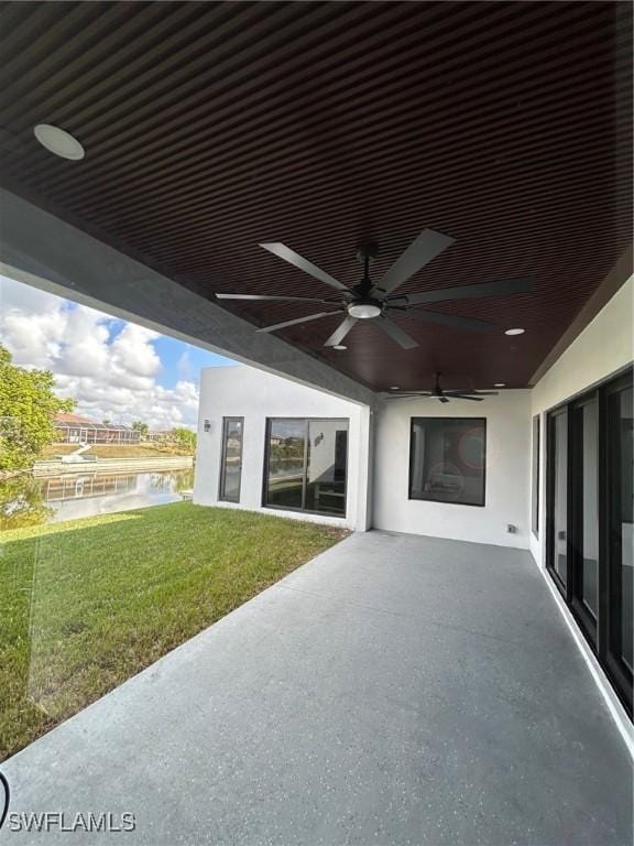 view of patio with ceiling fan and a water view