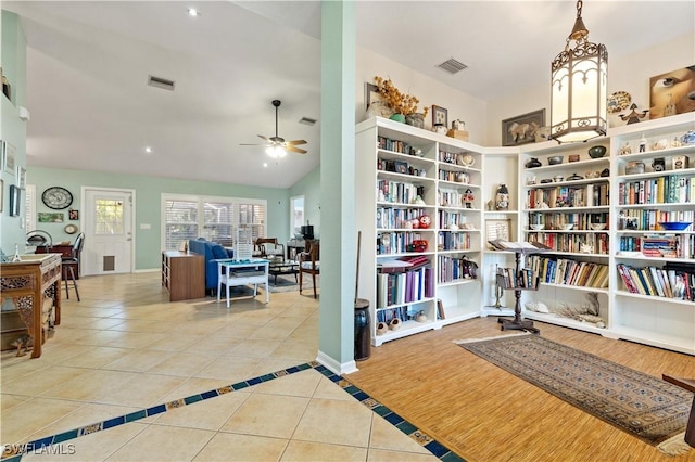 interior space featuring ceiling fan, light tile patterned flooring, and vaulted ceiling