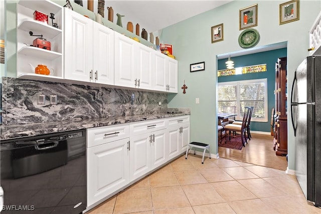 kitchen featuring white cabinets, light tile patterned floors, dark stone counters, and black appliances