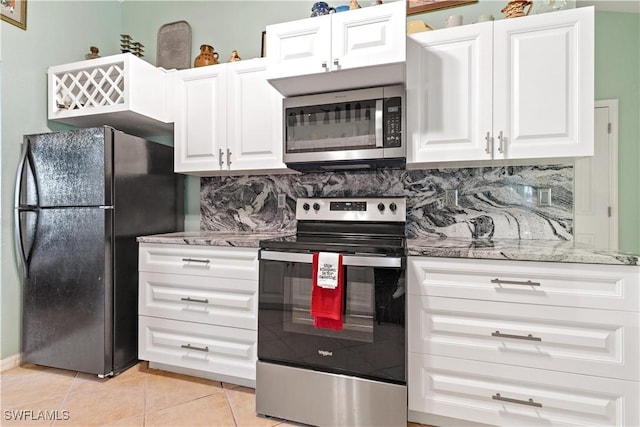 kitchen with light stone countertops, light tile patterned flooring, decorative backsplash, white cabinets, and appliances with stainless steel finishes