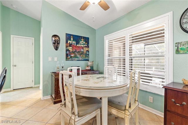 dining area featuring ceiling fan, light tile patterned floors, and vaulted ceiling