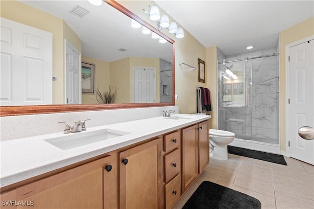 bathroom featuring tile patterned floors, vanity, toilet, and a shower with shower door