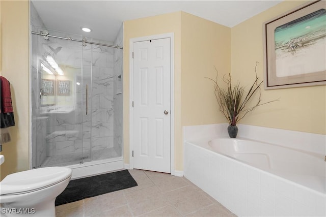 bathroom featuring tile patterned flooring, separate shower and tub, and toilet