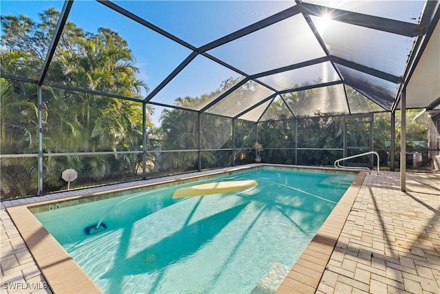 view of swimming pool with glass enclosure and a patio area