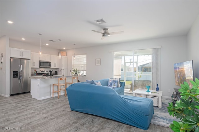 living room with ceiling fan and sink