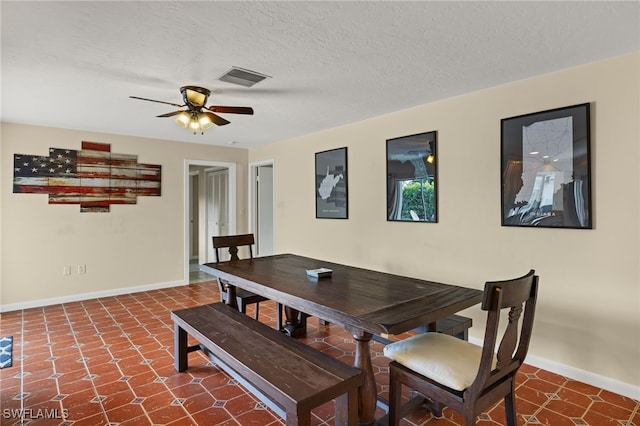 dining area with a ceiling fan, visible vents, a textured ceiling, and baseboards