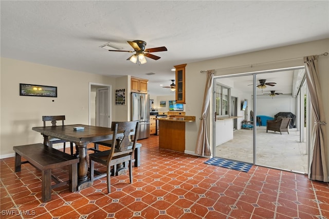 dining room with ceiling fan, baseboards, and a textured ceiling