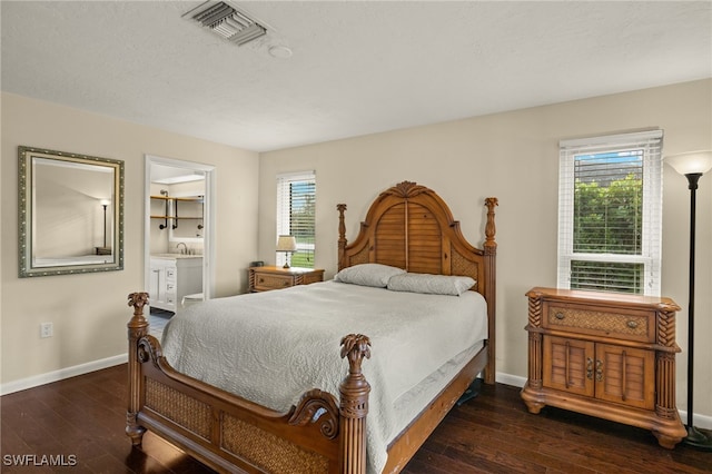 bedroom featuring multiple windows, visible vents, and dark wood-type flooring