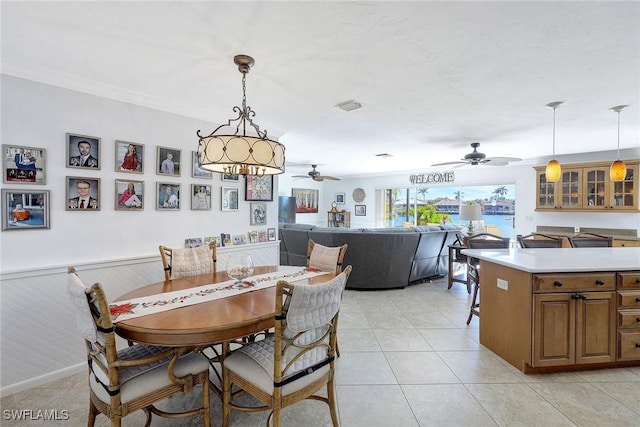 dining area featuring ceiling fan, light tile patterned flooring, and ornamental molding