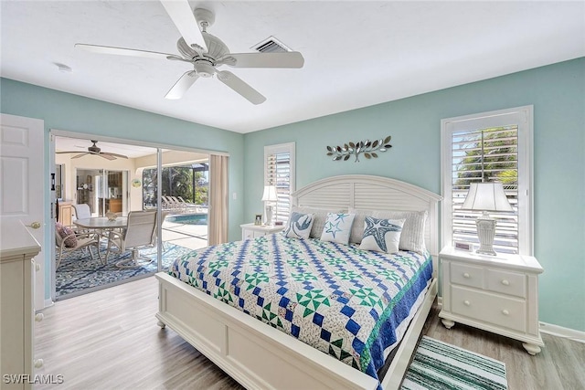 bedroom featuring hardwood / wood-style flooring, ceiling fan, access to outside, and multiple windows