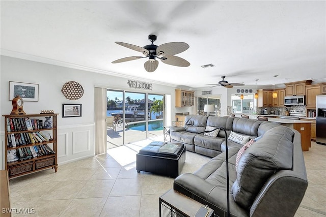 tiled living room featuring crown molding and ceiling fan