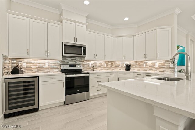 kitchen featuring white cabinetry, sink, light stone countertops, wine cooler, and appliances with stainless steel finishes