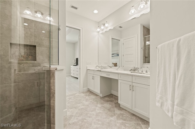 bathroom with vanity and tiled shower