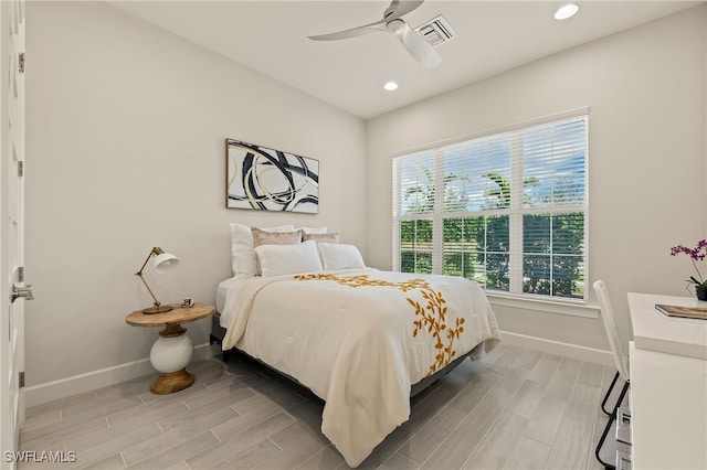 bedroom featuring multiple windows, ceiling fan, and hardwood / wood-style flooring