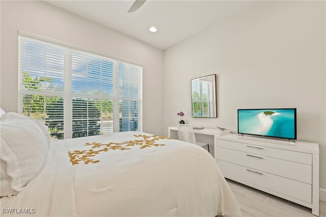 bedroom with ceiling fan, light wood-type flooring, and multiple windows