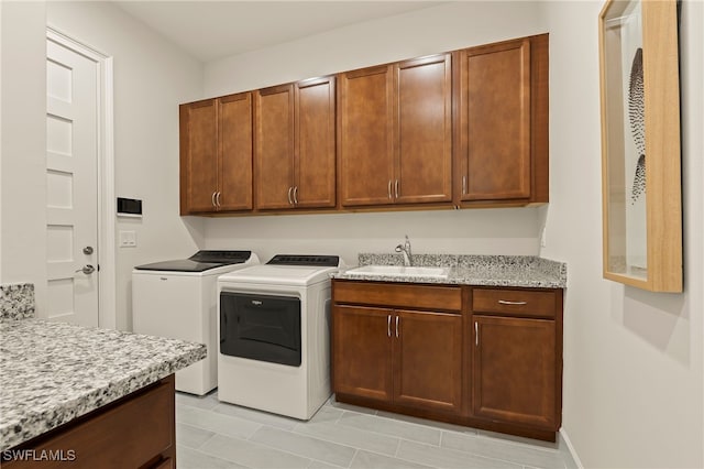 clothes washing area featuring cabinets, independent washer and dryer, and sink