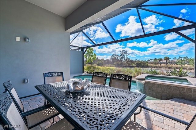 view of patio featuring glass enclosure, a swimming pool with hot tub, and a water view