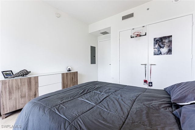 carpeted bedroom featuring electric panel and a closet