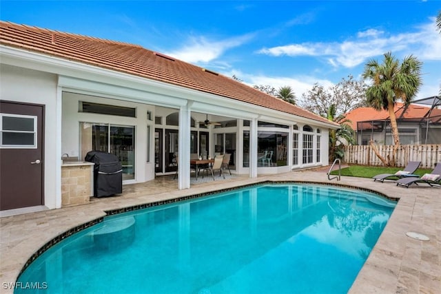 view of swimming pool featuring a grill, ceiling fan, and a patio area