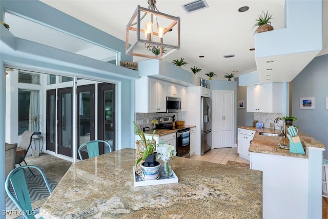 kitchen featuring decorative backsplash, stainless steel appliances, and white cabinetry