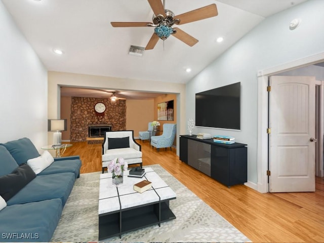 living room featuring ceiling fan, wood-type flooring, and vaulted ceiling