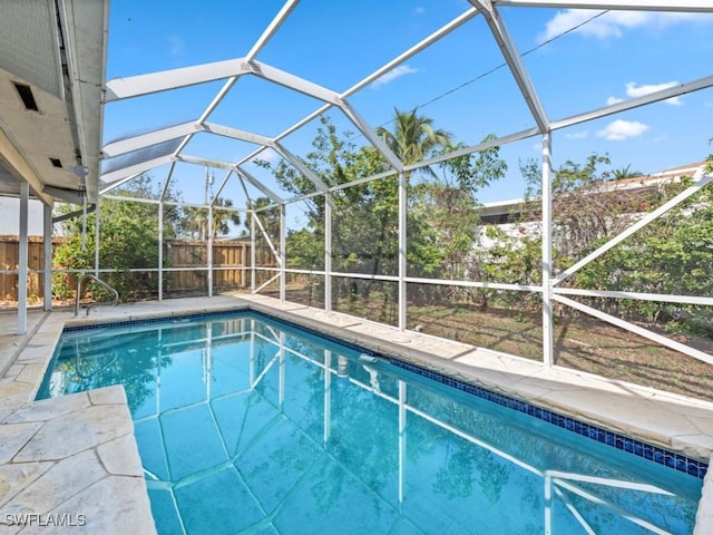 view of swimming pool featuring glass enclosure