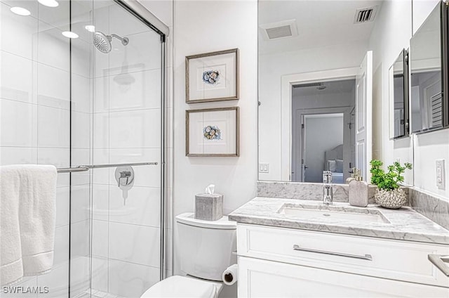 bathroom with toilet, vanity, and walk in shower