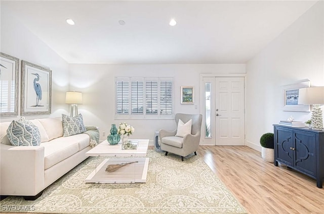 living room featuring lofted ceiling and light wood-type flooring