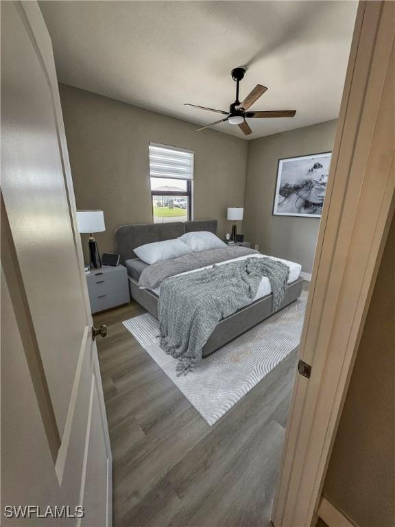 bedroom with ceiling fan and dark wood-type flooring