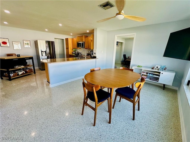 dining space with ceiling fan and sink