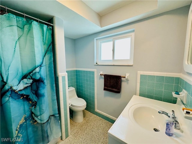 bathroom with a shower with curtain, vanity, toilet, and tile walls