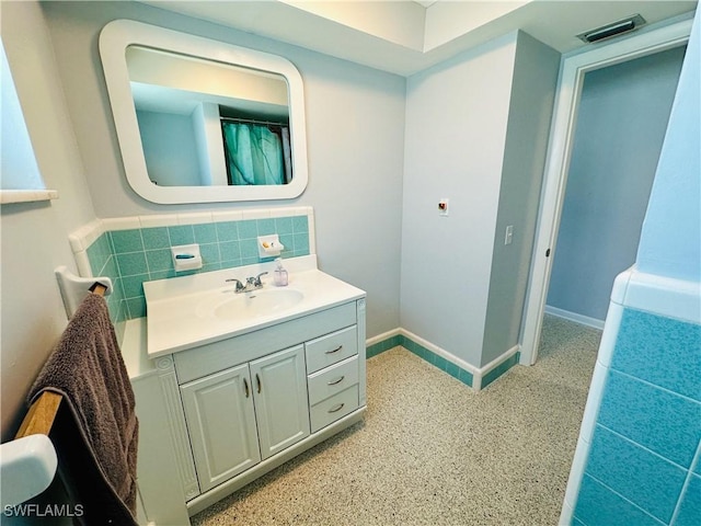 bathroom featuring vanity and backsplash