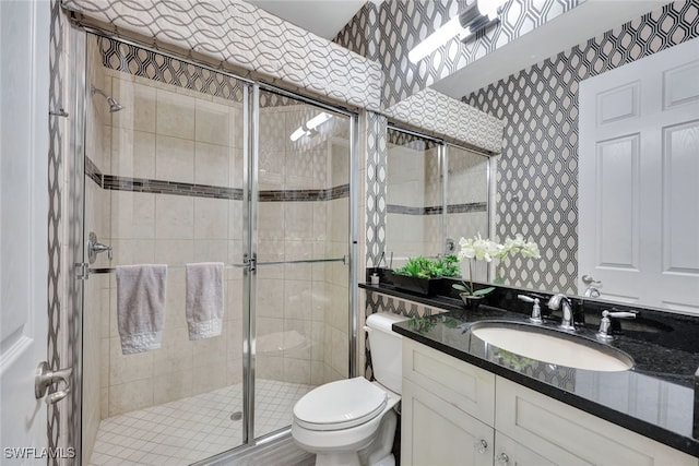 bathroom featuring vanity, toilet, and walk in shower