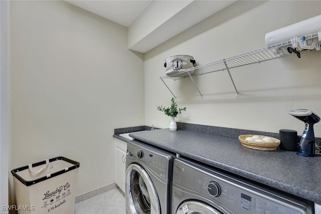 laundry room featuring cabinets, light tile patterned flooring, separate washer and dryer, and sink