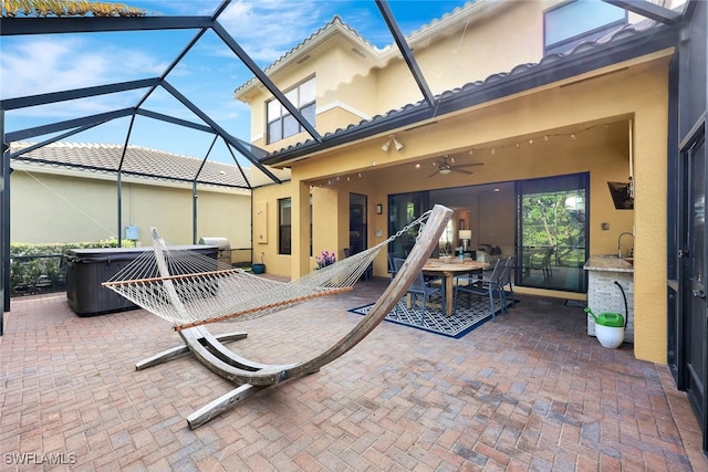 view of patio / terrace featuring ceiling fan and glass enclosure