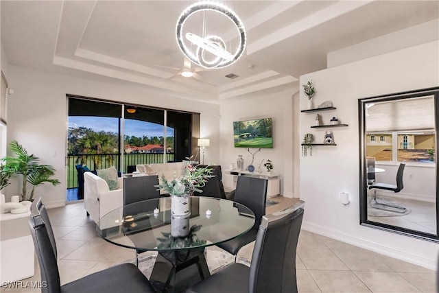 tiled dining area with a tray ceiling and an inviting chandelier