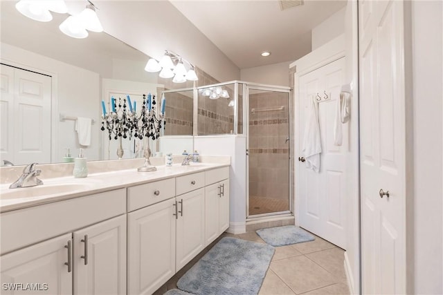 bathroom with tile patterned flooring, vanity, and walk in shower