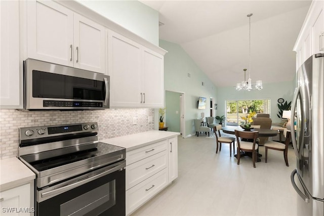 kitchen with white cabinets, a notable chandelier, stainless steel appliances, and hanging light fixtures