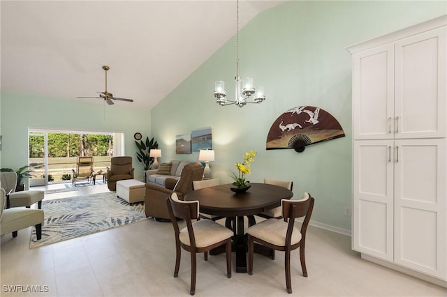 dining room featuring ceiling fan with notable chandelier and high vaulted ceiling