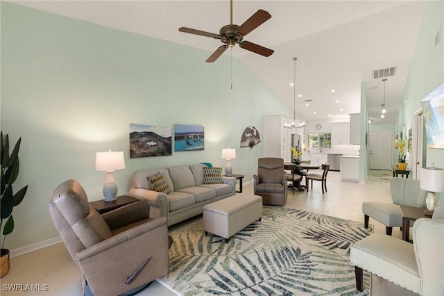 tiled living room with ceiling fan with notable chandelier and high vaulted ceiling