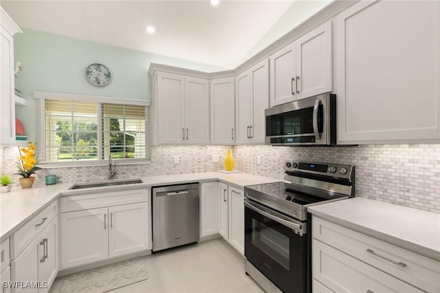 kitchen with backsplash, white cabinetry, sink, and appliances with stainless steel finishes