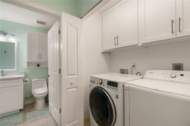 clothes washing area featuring independent washer and dryer and sink